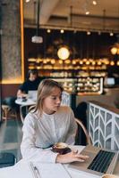 Young lady browsing the Internet at the cafe photo