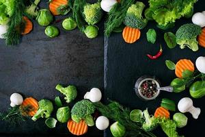 Fresh vegetables for a healthy diet on a dark background in a rustic style. Vegetarian food. Top view photo