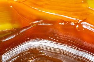Close up of orange colored industrial grease. Rich and thick texture of industrial grade grease used to smooth out all metal friction. Lubricating grease. close-up of yellow lithium grease for machine photo