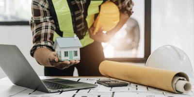 Close up of civil male engineer asian working on blueprint architectural project at construction site at desk in office. photo