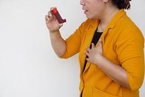 Closeup female patient uses brown asthma inhaler for relief asthma. Concept , Health care at home.  Pharmaceutical products for treatment symptoms of asthma or COPD. Use under prescription. photo