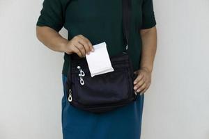 Closeup woman holds sanitary pad for menstruation to put into bag before going out. Concept, female's hygienic product for period's day. Woman healthcare. Monthly intimate hygiene. photo