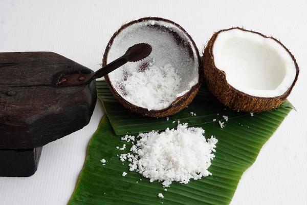 Close up of man hand grated coconut using an electric coconut grater in  Thailand Stock Photo