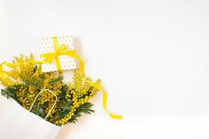 Yellow mimosa flowers frame with gift box. Womans day, easter , spring composition. Top view with copy space photo
