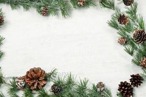 Christmas and New Year background with green spruce branches and pine cones, white banner, top view, copy space