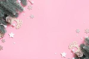 vista superior de la decoración navideña de año nuevo, plano sobre fondo rosa con espacio para copiar. tarjeta de felicitación en blanco de navidad foto