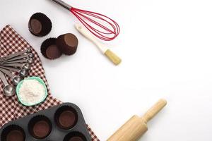 Top view kitchenware wooden rolling pin, wooden spatula and egg beater on white background. Materials or kitchen equipment for bakery. photo