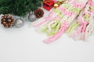 año nuevo o navidad de decoraciones coloridas y bufanda sobre fondo blanco. concepto de festival, temporada y tarjeta de felicitación. foto