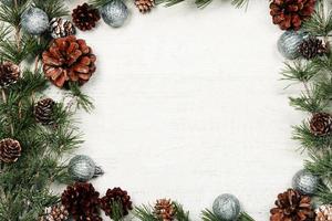 Christmas and New Year background with green spruce branches and pine cones, white banner, top view, copy space photo