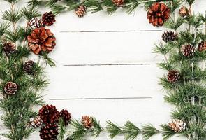 Christmas and New Year background with green spruce branches and pine cones, white banner, top view, copy space photo