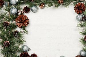 Christmas and New Year background with green spruce branches and pine cones, white banner, top view, copy space photo