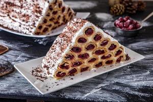 un postre o pastel moldavo tradicional que consiste en panqueques con cereza, crema de leche y crema de chocolate también llamado cosma lui guguta. foto