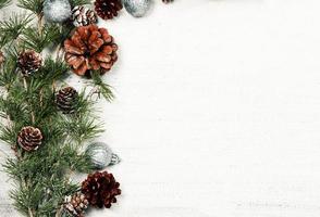 Christmas and New Year background with green spruce branches and pine cones, white banner, top view, copy space photo