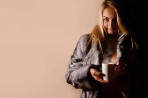 Girl in warm dress with coffee cup photo