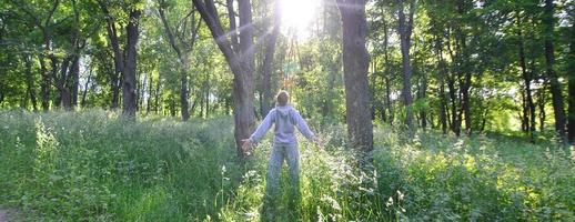 A young guy in a gray sports suit rejoices in the rising of the photo