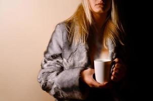 Girl in warm dress with coffee cup photo