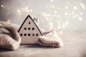 Ceramic house insulated by warm sweater. Winter holiday card photo