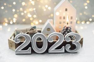 Christmas and New Year card. Number 2023 on holiday background. Christmas lights bokeh background. Holiday postcard. Happy New Year 2023 Card Concept photo