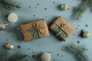 Christmas gift boxes, decoration and fir tree branch on blue background. Flat lay, top view photo