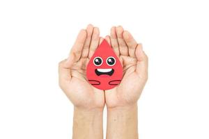 Hands holding blood drop paper cut on white background, Blood transfusion, World blood donor day. Blood Donation and Saving life Concept photo