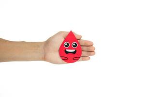 Hands holding blood drop paper cut on white background, Blood transfusion, World blood donor day. Blood Donation and Saving life Concept photo