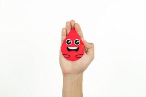 Hands holding blood drop paper cut on white background, Blood transfusion, World blood donor day. Blood Donation and Saving life Concept photo