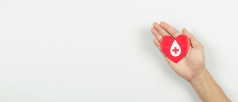 Hands holding heart for giving life paper cut on white background, Blood transfusion, World blood donor day. Blood Donation Concept photo