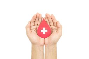 Hands holding blood drop paper cut on white background, Blood transfusion, World blood donor day. Blood Donation and Saving life Concept photo