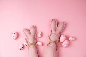 Pink toy bunnies on pink background .Flat lay banner.Happy easter banner. photo