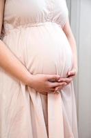 Vertical banner of young pregnant woman holding the belly. Expecting a child, motherhood concept photo