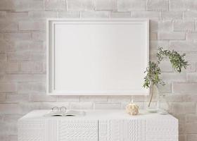Empty horizontal picture frame on white brick wall in modern living room. Mock up interior in minimalist, contemporary style. Free space for your picture, poster. Console, candle, plant. 3D rendering. photo