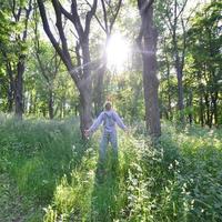 A young guy in a gray sports suit rejoices in the rising of the photo