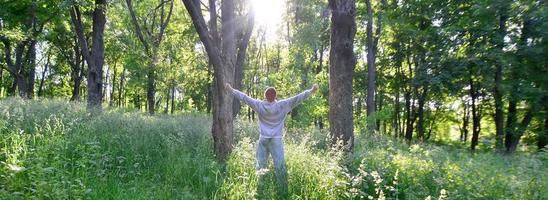A young guy in a gray sports suit rejoices in the rising of the photo