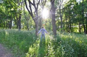 A young guy in a gray sports suit rejoices in the rising of the photo