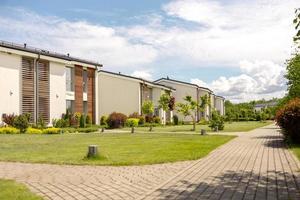 fila de cabañas modernas. hilera de casas unifamiliares a estrenar. diseño moderno de residencias de vida urbana con patios privados, acabados sofisticados, nuevo desarrollo. instalaciones verdes al aire libre, césped foto