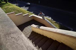 A young guy performs a jump through the space between the concrete parapets. The athlete practices parkour, training in street conditions. The concept of sports subcultures among youth photo