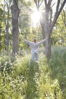 A young guy in a gray sports suit rejoices in the rising of the photo