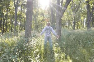 A young guy in a gray sports suit rejoices in the rising of the photo