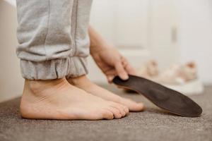 diagnóstico de pies planos y ortesis, plantillas para zapatos. problemas de pie plano, dolor. identificación del pie plano. tratamiento de la fascitis plantar. pie de mujer y plantillas en casa, vista de cerca. foto