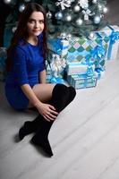 Girl sitting with gifts under the Christmas tree photo