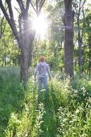 A young guy in a gray sports suit stands opposite the sun among photo