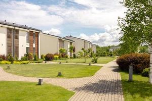 fila de cabañas modernas. hilera de casas unifamiliares a estrenar. diseño moderno de residencias de vida urbana con patios privados, acabados sofisticados, nuevo desarrollo. instalaciones verdes al aire libre, césped foto