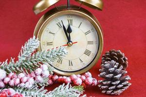 Christmas snow fir tree, alarm clock and gift bag on red background. photo