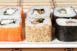 Sushi Assortment On White Dish over bamboo background. photo