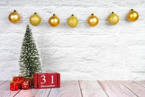 árbol de navidad decorativo, cajas de regalo y calendario de madera sobre fondo blanco de madera. foto