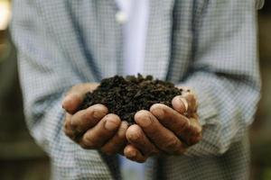 Farmer holding soil in hands close-up. photo