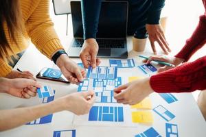 UX developer and ui designer brainstorming about mobile app interface wireframe design with customer breif and color code at modern office. photo