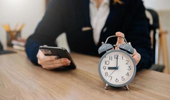 Alarm clock on the desk. Business working in modern office building or home at night using laptop. photo