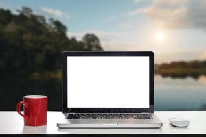 Front view of cup and laptop on table photo