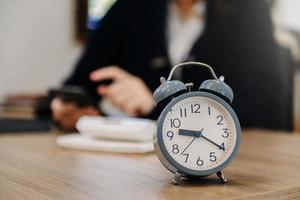 Alarm clock on the desk. Business working in modern office building or home at night using laptop. photo